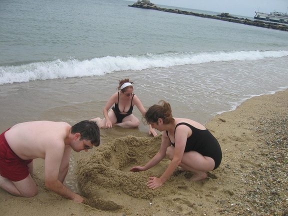 Pale adults build sandcastle